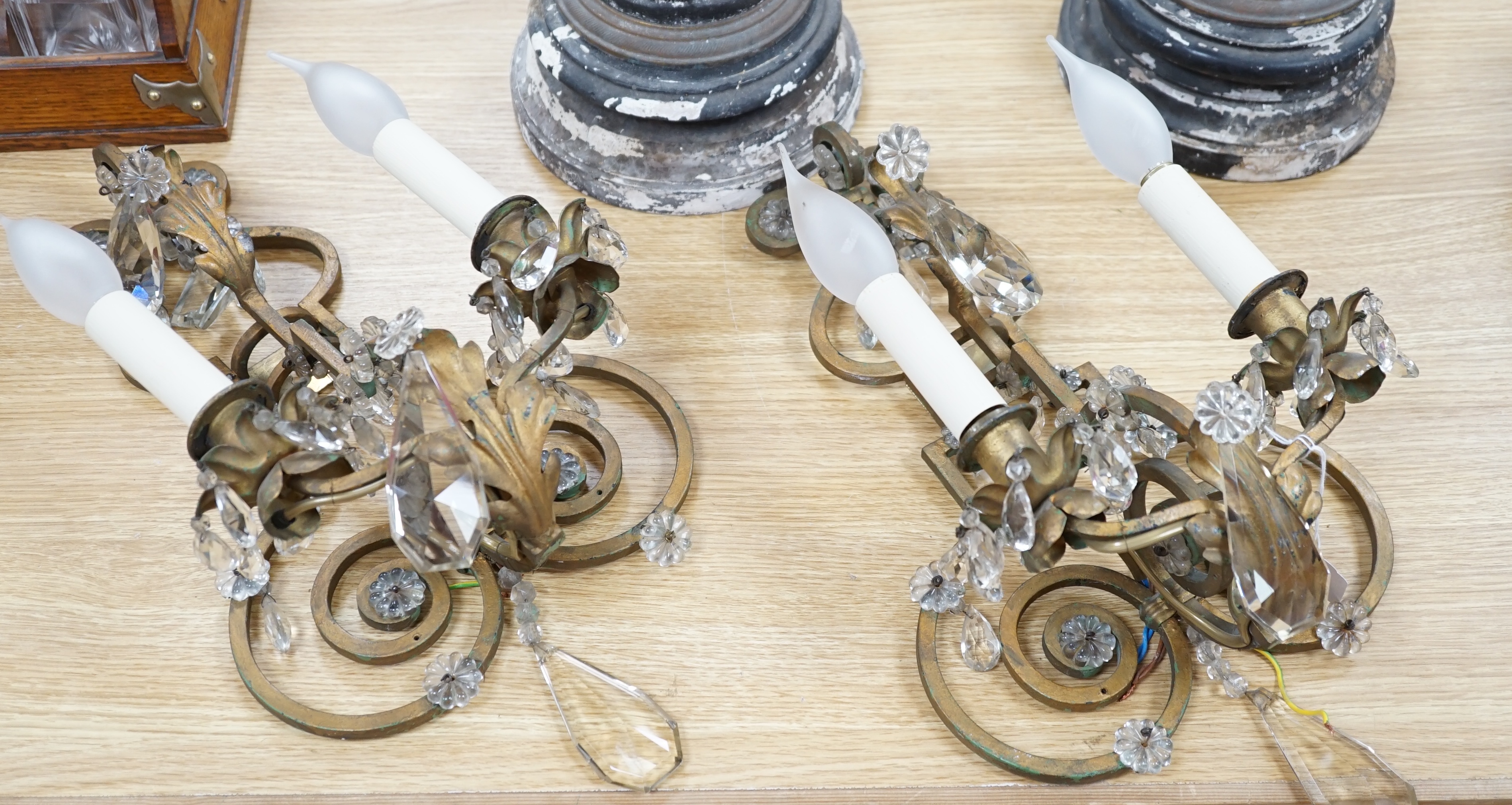A pair of two branch gilt painted metal wall lights with lustre drops, approximately 44cm high. Condition - fair to good